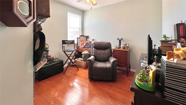 sitting room with hardwood / wood-style flooring and ceiling fan