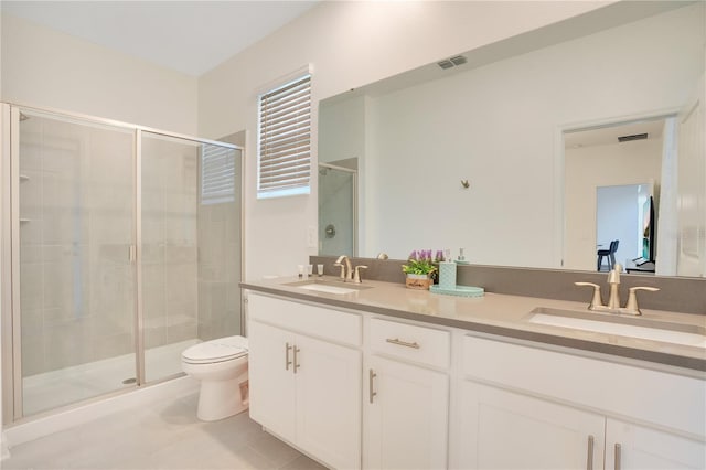 bathroom featuring vanity, toilet, a shower with shower door, and tile patterned flooring