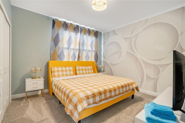 bedroom featuring carpet floors, a closet, and a notable chandelier