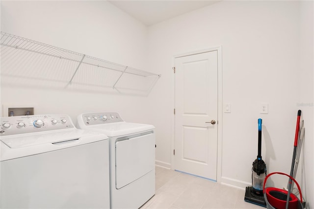 laundry room featuring independent washer and dryer and light tile patterned floors