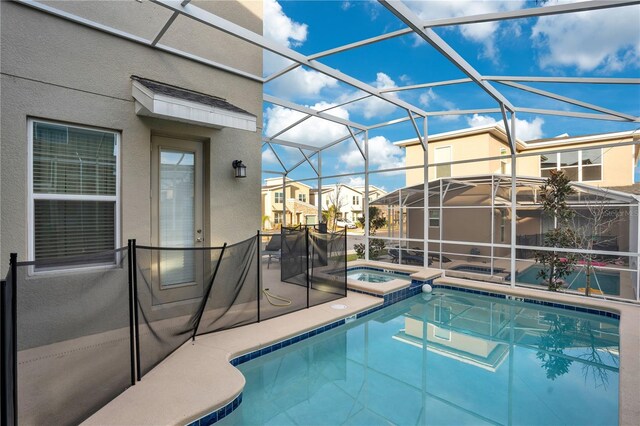 view of pool featuring an in ground hot tub, a patio area, and glass enclosure