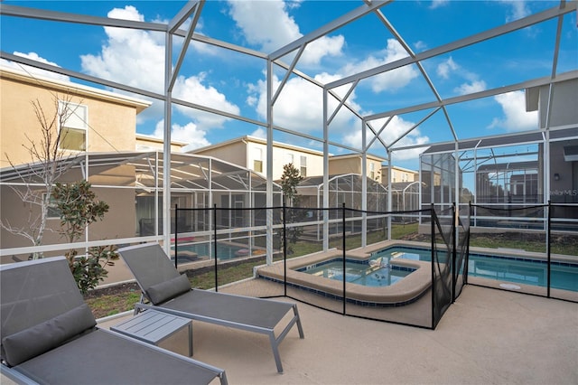 view of patio / terrace featuring a swimming pool with hot tub and glass enclosure