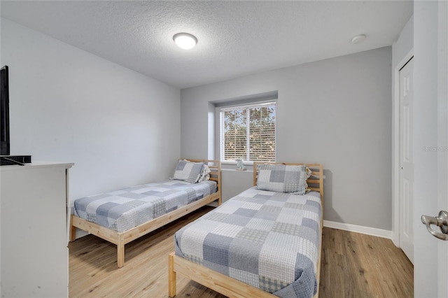 bedroom with light hardwood / wood-style flooring and a textured ceiling