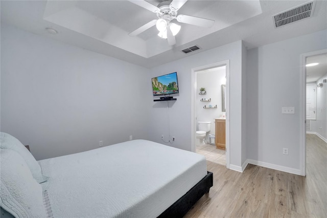 bedroom featuring connected bathroom, light hardwood / wood-style flooring, and ceiling fan