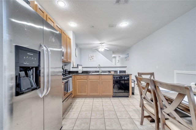 kitchen with sink, ceiling fan, light tile patterned floors, a textured ceiling, and stainless steel appliances