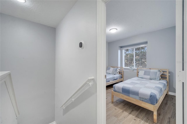 bedroom featuring light wood-type flooring and a textured ceiling