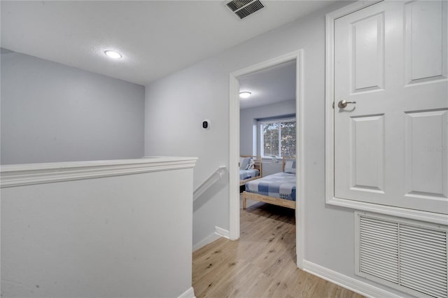 hallway featuring a textured ceiling and light wood-type flooring