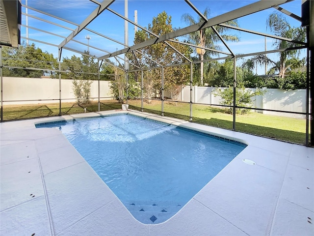 view of pool with a patio, a yard, and glass enclosure