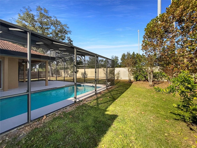 view of pool featuring a lawn and glass enclosure