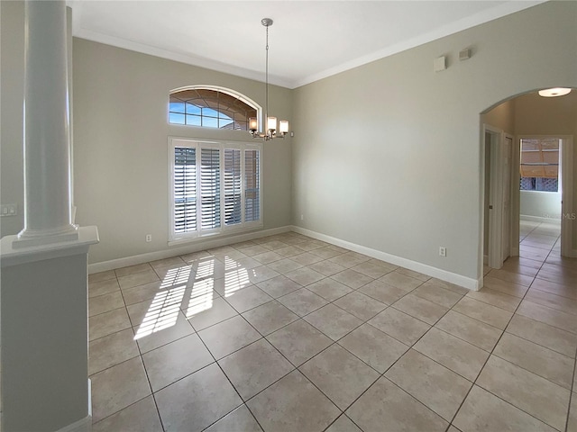 unfurnished dining area with light tile patterned floors, decorative columns, an inviting chandelier, and ornamental molding