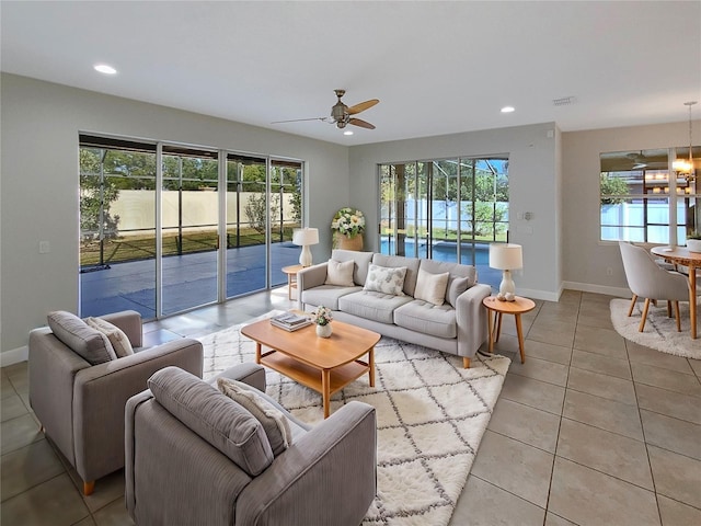 tiled living room featuring ceiling fan and a healthy amount of sunlight