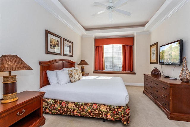 bedroom with a raised ceiling, ceiling fan, light colored carpet, and ornamental molding