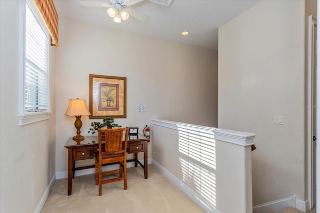 carpeted home office featuring ceiling fan