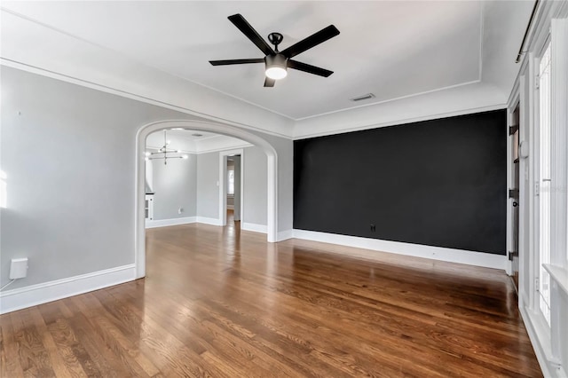 spare room featuring wood-type flooring, ceiling fan with notable chandelier, and ornamental molding