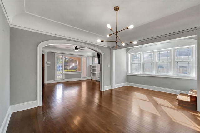 unfurnished dining area with crown molding, dark hardwood / wood-style flooring, and ceiling fan with notable chandelier