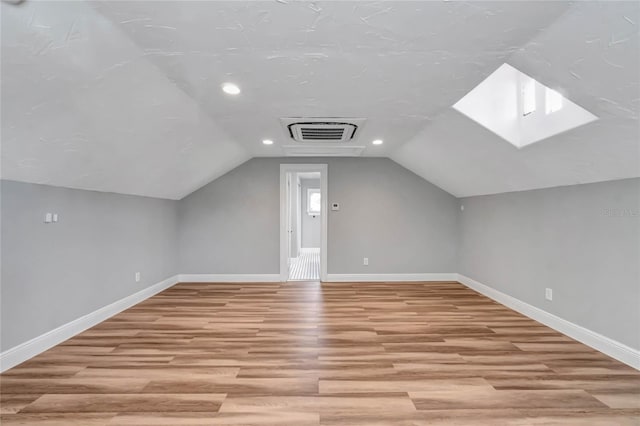 additional living space with lofted ceiling and light wood-type flooring