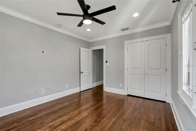 unfurnished bedroom with ceiling fan, a closet, dark hardwood / wood-style floors, and multiple windows