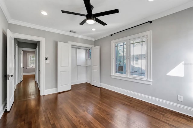 unfurnished bedroom featuring ceiling fan, a closet, dark wood-type flooring, and ornamental molding