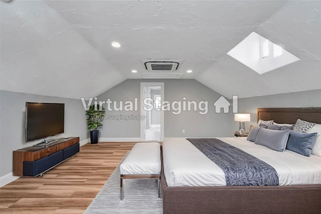 bedroom featuring light wood-type flooring and vaulted ceiling