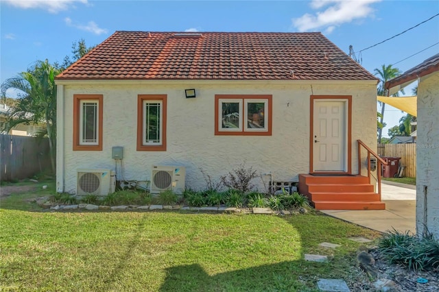 rear view of house with ac unit, a yard, and a patio