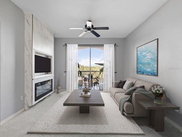 carpeted living room with a fireplace and ceiling fan