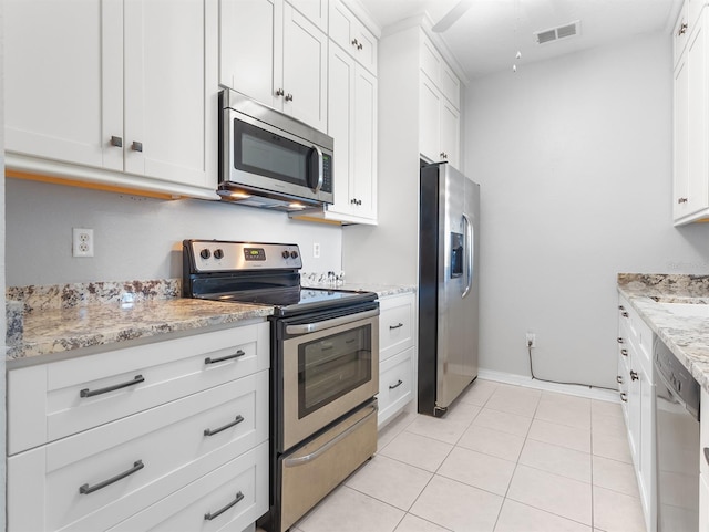 kitchen featuring white cabinetry, stainless steel appliances, and light tile patterned floors