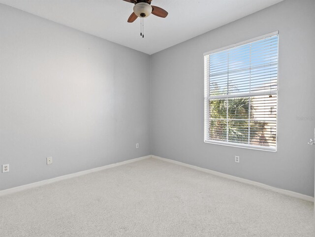 carpeted spare room with ceiling fan