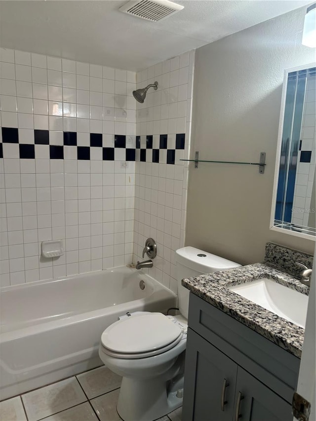 full bathroom featuring tile patterned floors, toilet, tiled shower / bath combo, and vanity