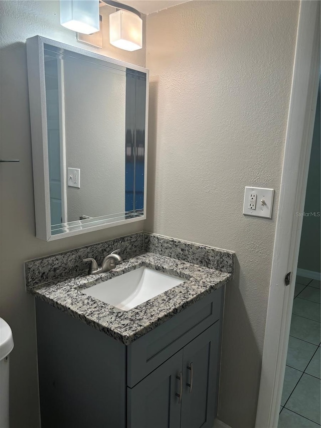 bathroom with toilet, tile patterned floors, and vanity