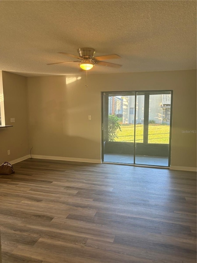 unfurnished room featuring a textured ceiling, ceiling fan, dark hardwood / wood-style flooring, and a healthy amount of sunlight