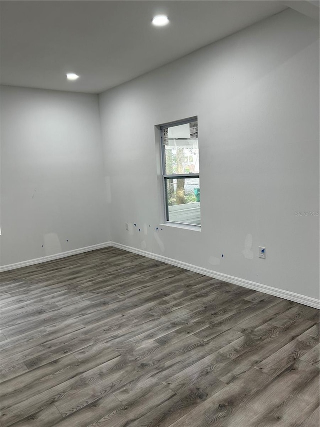 unfurnished room with dark hardwood / wood-style flooring