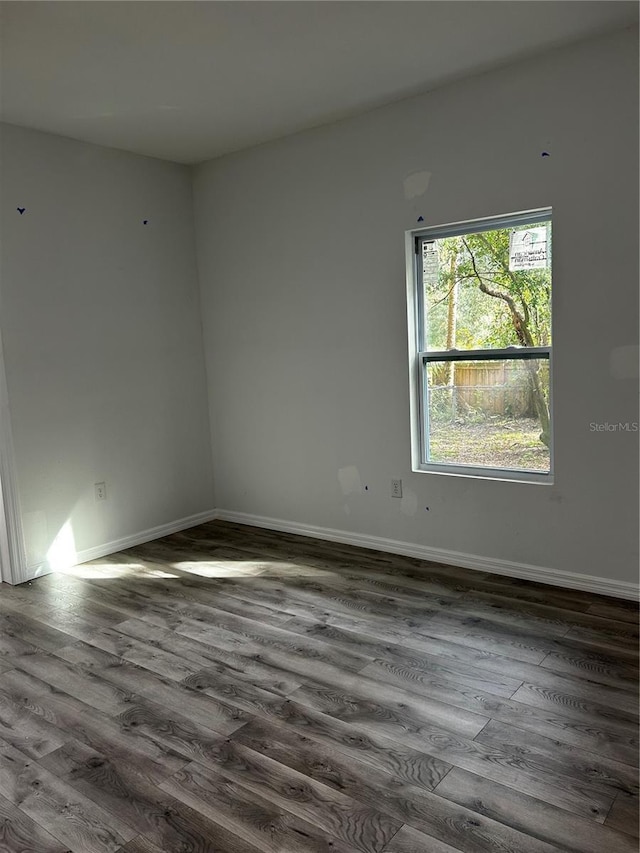 unfurnished room with dark hardwood / wood-style flooring