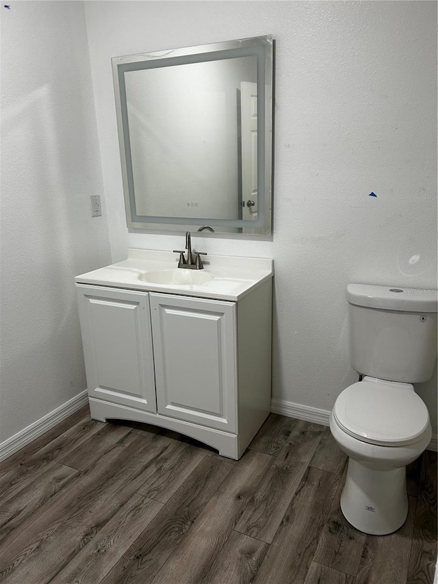 bathroom with vanity, hardwood / wood-style flooring, and toilet