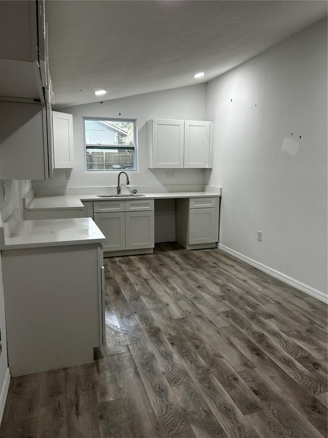 kitchen with sink, dark hardwood / wood-style floors, and vaulted ceiling