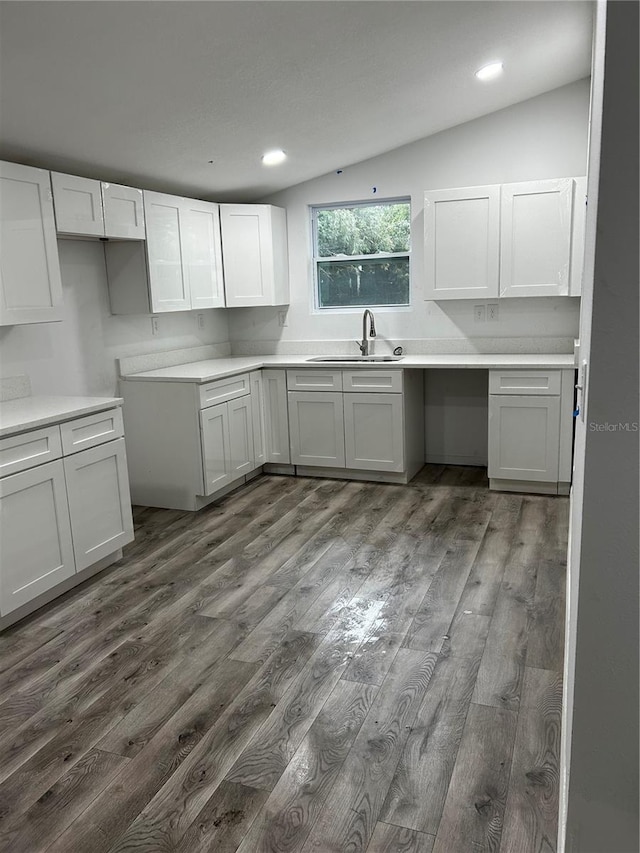 kitchen featuring dark hardwood / wood-style flooring, sink, and vaulted ceiling