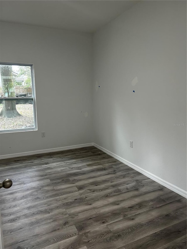 empty room with dark hardwood / wood-style flooring