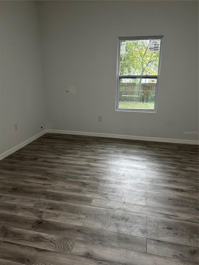 spare room with dark wood-type flooring