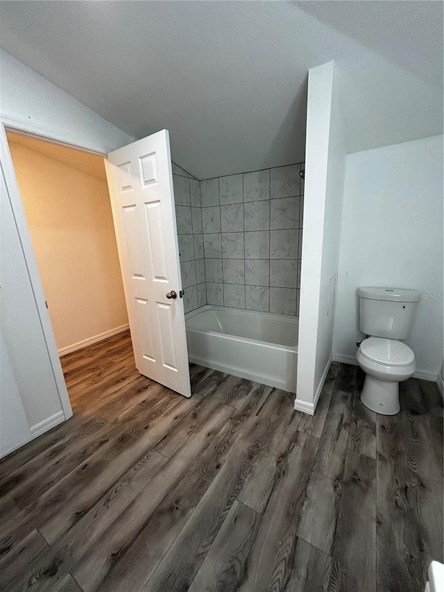 bathroom featuring hardwood / wood-style floors, vaulted ceiling, and toilet