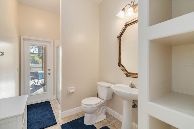 bathroom with tile patterned floors, toilet, a shower with shower door, and sink