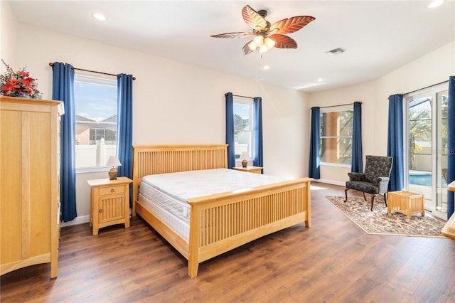 bedroom featuring dark hardwood / wood-style flooring, multiple windows, and ceiling fan