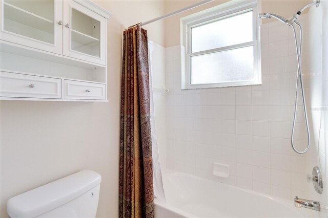 bathroom featuring shower / bath combination with curtain and toilet