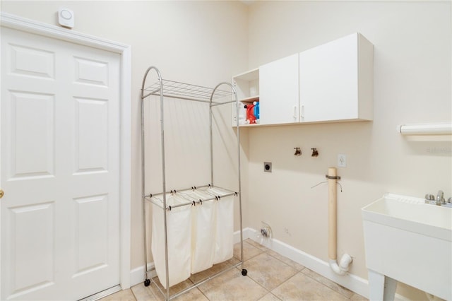 laundry area featuring electric dryer hookup, cabinets, sink, hookup for a washing machine, and light tile patterned floors