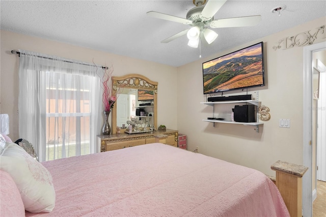 bedroom featuring ceiling fan and a textured ceiling