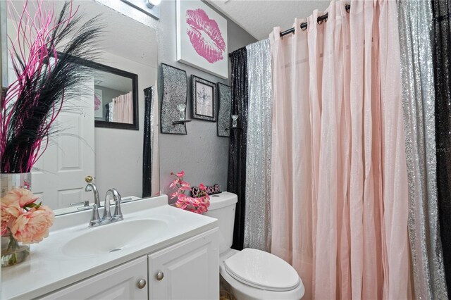 bathroom with vanity, a textured ceiling, and toilet