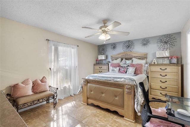 bedroom with ceiling fan, light tile patterned floors, and a textured ceiling