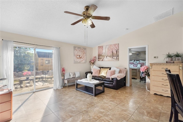 tiled living room with ceiling fan, a textured ceiling, and vaulted ceiling