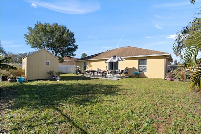 back of house featuring a patio area, a storage shed, and a lawn