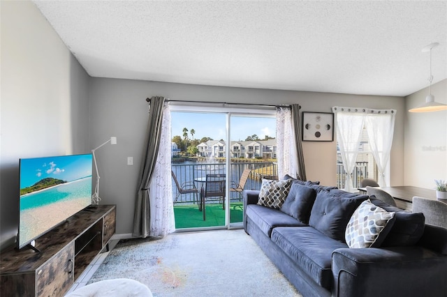 living room featuring carpet flooring, a water view, and a textured ceiling