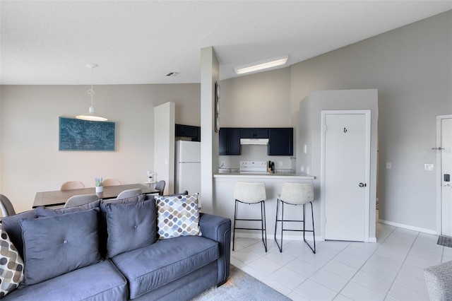 living room featuring a textured ceiling, light tile patterned floors, and vaulted ceiling