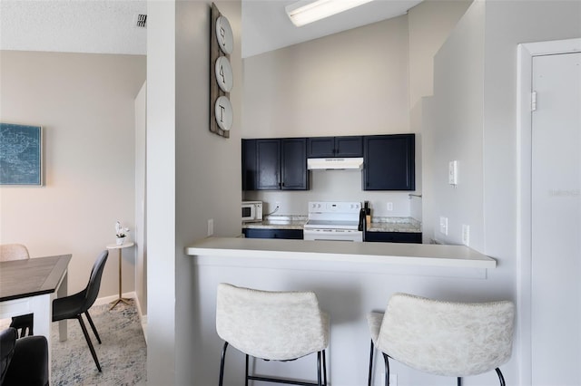 kitchen featuring a breakfast bar, white appliances, kitchen peninsula, and lofted ceiling